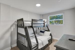 Un dormitorio con dos literas y una ventana. en Vibrant Miami Escape with BBQ Grill Free WiFi & Parking, en North Miami Beach