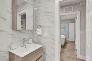 Un baño blanco con lavabo y espejo. en Vibrant Miami Escape with BBQ Grill Free WiFi & Parking, en North Miami Beach 25 fotos más