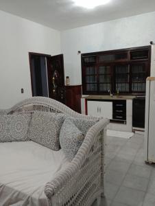 a living room with a bed and a kitchen at Casa tucano in São Sebastião