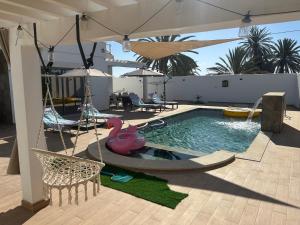 a swimming pool with a pink flamingo in the water at Grande Villa Familiale Route Du Phare in Djerba