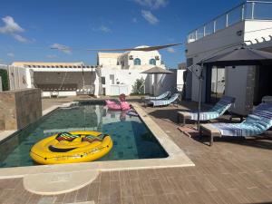 a swimming pool with a yellow boat in it at Grande Villa Familiale Route Du Phare in Djerba