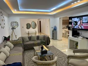 a living room with a couch and a flat screen tv at Grande Villa Familiale Route Du Phare in Djerba