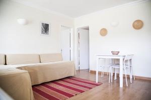 a living room with a couch and a table at Sintra Sol - Apartamentos Turisticos in Sintra