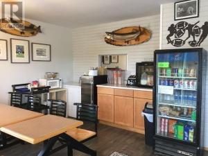 Una cocina con refrigerador y una mesa con sillas. en Northside Motel, en Vermilion Bay