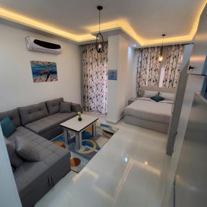ein Wohnzimmer mit einer Couch und einem Bett in der Unterkunft SHL Hurghada Airport Aparthotel - By SAHLHOMES in Hurghada