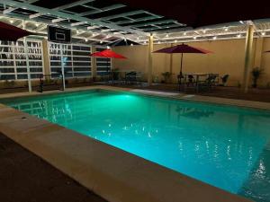 a large swimming pool with blue water at night at Cabaña Hacienda Ridvan in Aguascalientes