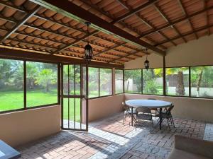 a screened in porch with a table and chairs at Cabaña Hacienda Ridvan in Aguascalientes