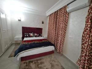 Un dormitorio con una cama y una ventana con cortinas. en résidence ATLASS, en Marrakech