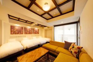 a living room with two beds and a couch at Hotel Sanrriott Kitahama in Osaka