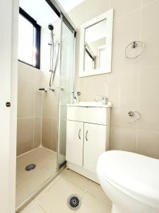 ein Badezimmer mit Dusche, Toilette und Waschbecken in der Unterkunft A Cozy 2B2B Apartment near Airport & Train Station in Sydney + 24 Fotos