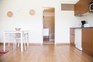a kitchen with a table and a white table and chairs at Sintra Sol - Apartamentos Turisticos in Sintra