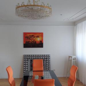 a dining room with a table and chairs and a chandelier at VIENNA & ENJOY `s in Leopoldsdorf +9 photos