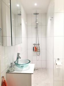 a bathroom with a glass sink and a shower at Nordic Host - Deichmans Gate 10 in Oslo