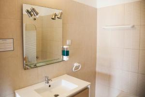 a bathroom with a sink and a shower with a mirror at Sintra Sol - Apartamentos Turisticos in Sintra