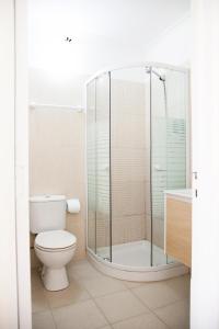 a bathroom with a toilet and a glass shower at Sintra Sol - Apartamentos Turisticos in Sintra