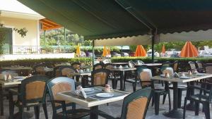 a group of tables and chairs at a restaurant at Gefyra Rooms in Ancient Epidauros