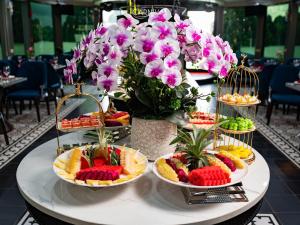 une table avec plusieurs assiettes de nourriture et de fleurs dans l'établissement Golden Cruise luxury, à Hạ Long