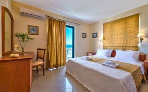 a hotel room with a large bed and a desk at Antilia Apartments in Tavronitis
