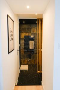 - une salle de bains pourvue d'une douche à l'italienne à côté d'un couloir dans l'établissement Appartement Chic & Élégant proche de la mer, à Yffiniac