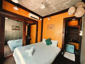 une chambre avec deux lits dans une pièce aux murs orange dans l'établissement Nhà Saigon Homestay&Coffee, à Hô-Chi-Minh-Ville 53 autres photos