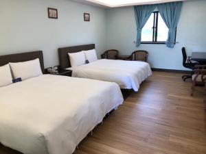 Postel nebo postele na pokoji v ubytování Menippe Hotel Kaohsiung