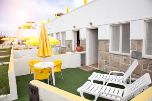 a patio with chairs and tables and an umbrella at Sintra Sol - Apartamentos Turisticos in Sintra