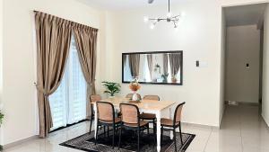 a dining room with a wooden table and chairs at DLaman Hijau in Merlimau