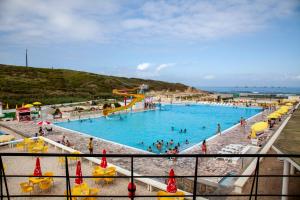 a large swimming pool with people in the water at Sintra Sol - Apartamentos Turisticos in Sintra