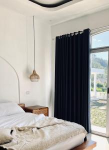 a bedroom with a bed and a window at Montana villas by volcano garden in Kubupenlokan