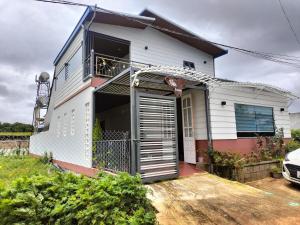 a white house with a garage at Yên Homestay Đơn Dương in Da Lat