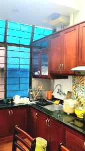 a kitchen with wooden cabinets and a large window at Nhà riêng 3 phòng ngủ 6 giường in Hanoi