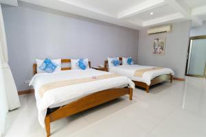 two beds in a room with white floors at Baan Suan Khun Ta and Golf Resort in Ubon Ratchathani +67 photos