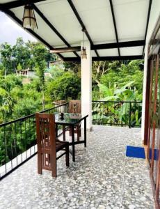 eine Terrasse mit Tisch und Stühlen auf einem Balkon in der Unterkunft Angel's View Cottage Ella in Ella + 31 Fotos