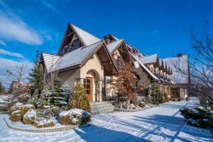 a house in the snow with a roof at Pensjonat Pod Tatrami in Szaflary