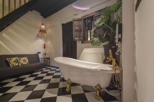 a bathroom with a tub and a checkered floor at Ohana House-33 in Malacca