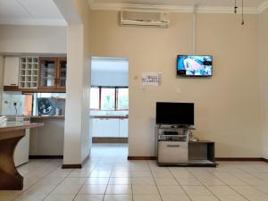 a living room with a flat screen tv on the wall at 9 Spiritual Fruits in Durban