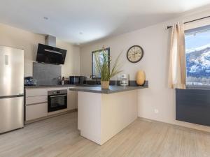 eine Küche mit einer Theke und einer Uhr an der Wand in der Unterkunft Maison Neuve 7 Pers Loudenvielle Proche Centre avec Wifi - FR-1-695-65 in Loudenvielle