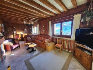 un salon avec un canapé et une télévision dans l'établissement Chalet spacieux avec cheminée et salle de cinéma à Montgenèvre - FR-1-266-242, à Montgenèvre
