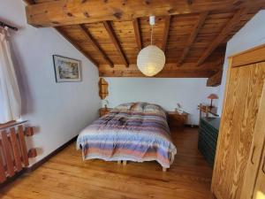 une chambre avec un lit et un plafond en bois dans l'établissement Chalet spacieux avec cheminée et salle de cinéma à Montgenèvre - FR-1-266-242, à Montgenèvre