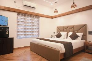 a bedroom with a large bed and a window at Flower Hill Cottage in Varkala