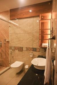 a bathroom with a toilet and a sink at Flower Hill Cottage in Varkala +76 photos