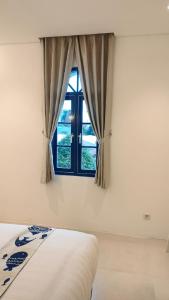 a bedroom with a bed and a window at Little Mykonos in Bandung +45 photos