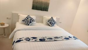 a bed with blue and white sheets and pillows at Little Mykonos in Bandung