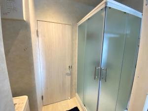 a shower with a glass door in a bathroom at Tamari House, a mansion with coral islands and natural pools in Amami +15 photos