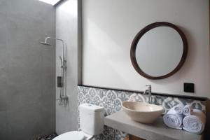 Un baño con lavabo, espejo e inodoro. en Dtwins Ubud Villa, en Tegalalang 19 fotos más