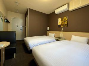 Un ou plusieurs lits dans un hébergement de l'établissement Hotel Route-Inn Miyako