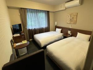 Un ou plusieurs lits dans un hébergement de l'établissement Hotel Route-Inn Miyako