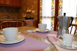 uma mesa com duas xícaras e pires sobre uma mesa em Appartamenti Giacomo Noventa em Noventa di Piave