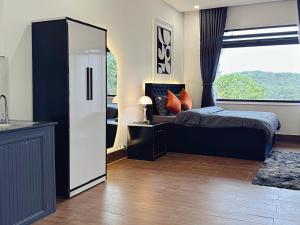 una camera da letto con un letto e una grande finestra di Thái Bảo Châu 3 - Homestay a Da Lat