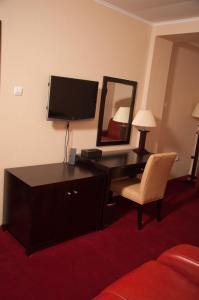 Cette chambre comprend un bureau avec un miroir et une chaise. dans l'établissement Hotel Baden, à Călăraşi
